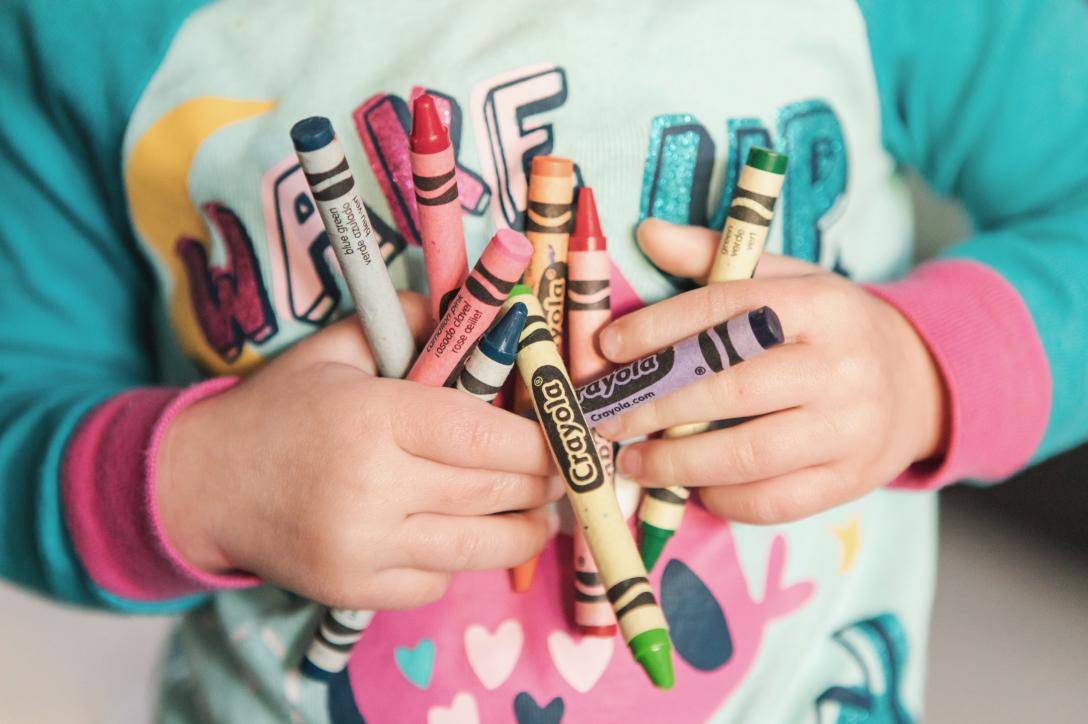 Kid holding crayons